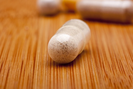 Medical pill against diseases on a wooden table.の写真素材