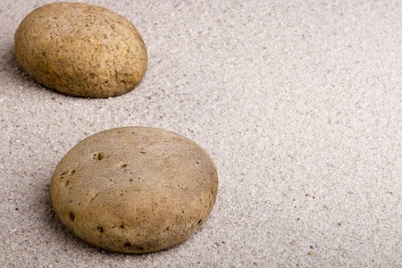 Close-up of a brown stone laying on brown sand.の写真素材
