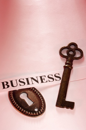 A key laying on a piece of paper with the word "business" on it.の写真素材