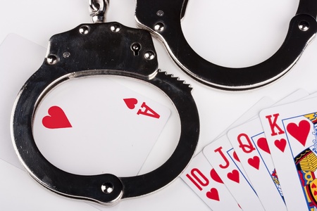 Handcuffs with things gaming - playing cards on a white background.