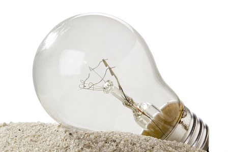 Light bulb on sand isolated on a white background.の写真素材
