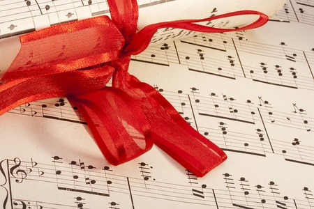 Theme music, old musical notes with roll bandaged red ribbon.の写真素材