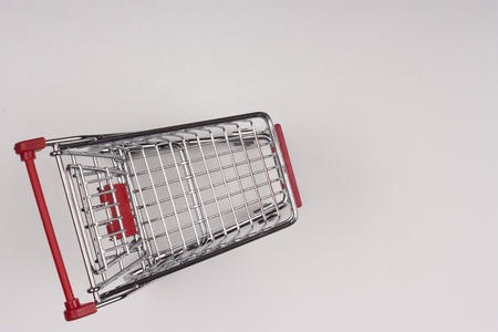 Empty shopping cart with the red handle on a white background.の写真素材