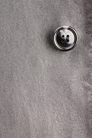 Close-up photograph of a gray button on gray fabric. Add your text to the background.の写真素材