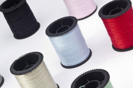 Close-up photograph of a light blue spool of thread among other spools.