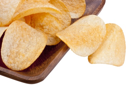 Potato chips from organic products in a wooden plate.