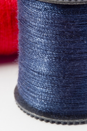 Close-up photograph of blue thread spool on a white background.