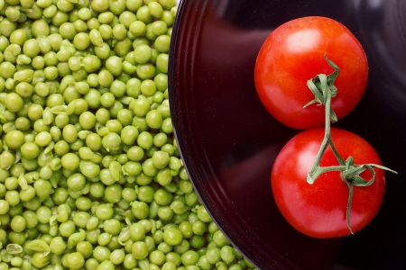 Directly above photograph of red tomatoes and green peas.の写真素材