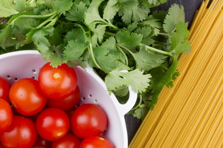 Directly above photograph of red tomatoes, parsley, and pasta.の写真素材