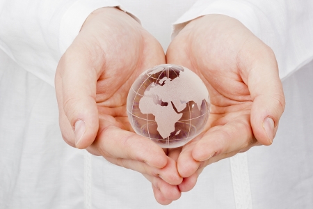 Close-up image of a glass globe in man's hands.の写真素材