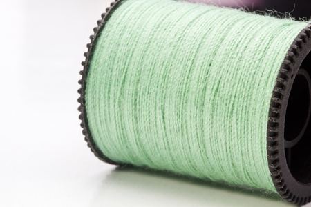 Close-up photograph of a green spool of thread.