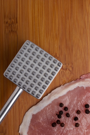 Aluminium meat tenderizer on wooden background. Kitchen equipmentの写真素材