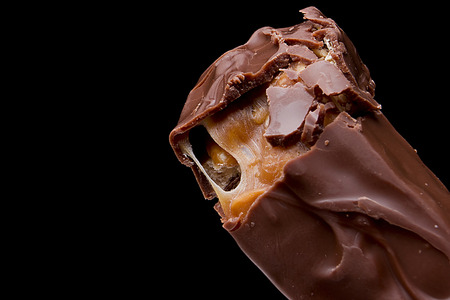Chocolate bar with caramel on a black background.