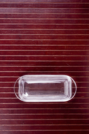 Butterdish of glass on a wooden surface. Food.の写真素材
