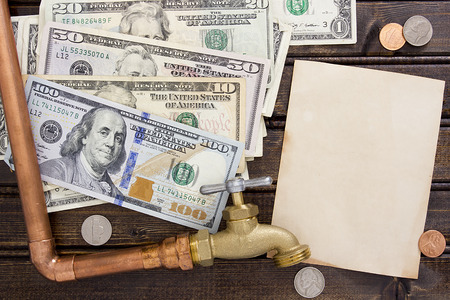 Financial charges for water. Water faucet on a background of dollars.の写真素材