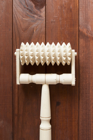 Handmade wooden massager on a wooden surface.の写真素材