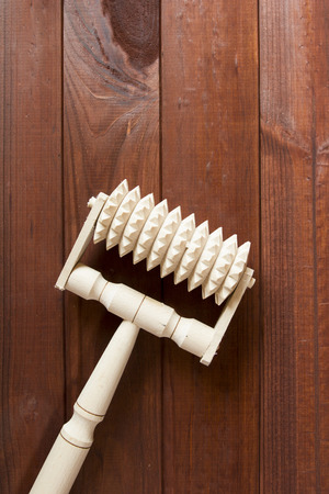 Handmade wooden massager on a wooden surface.の写真素材