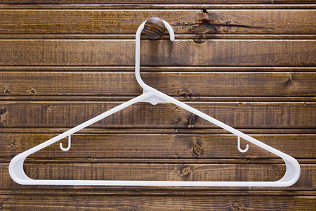 White clothes hanger on a wooden wall.の写真素材