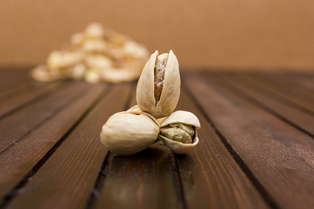 Pistachios on a wooden surface in the background slide of the shell.の写真素材