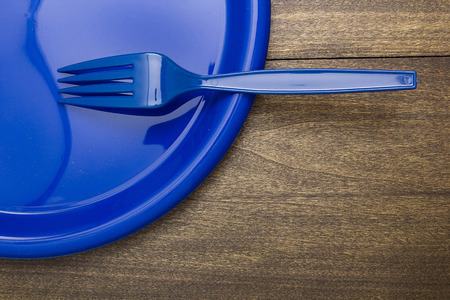 Plastic disposable fork and plates for going on a picnic.の写真素材