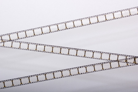 Photo of the old film, unwound from a roll over a white background.の写真素材