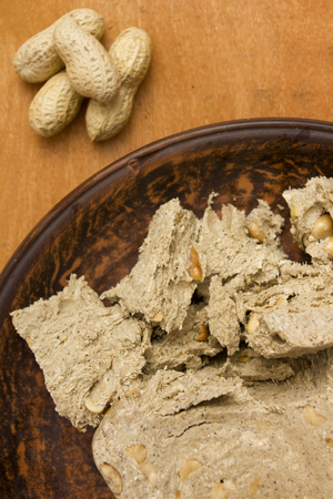 Slice of halva with peanuts on a ceramic plate.の写真素材