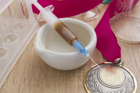 Ceramic mortar, medical equipment and a medal on wooden backgroundの写真素材