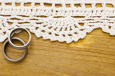 Wedding rings and lace on the wooden backgroundの写真素材