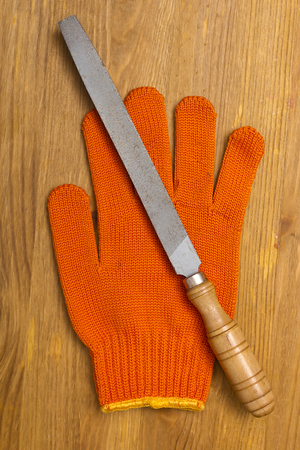 Files and work gloves on a wooden table available to workの写真素材