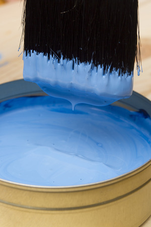 Brush for paint and paint on a wooden background