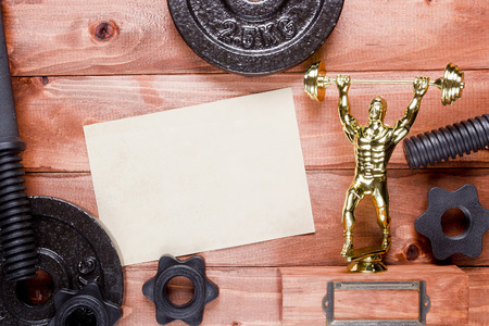 Figure weightlifter and dumbbells on a wooden backgroundの写真素材