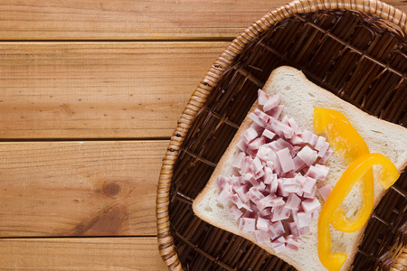 Open sandwich in a wicker basket on a wooden tableの写真素材