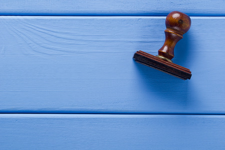 Wooden stamp on a blue wooden backgroundの写真素材