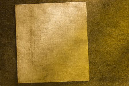Dirty old sheet of paper on dark wooden backgroundの写真素材