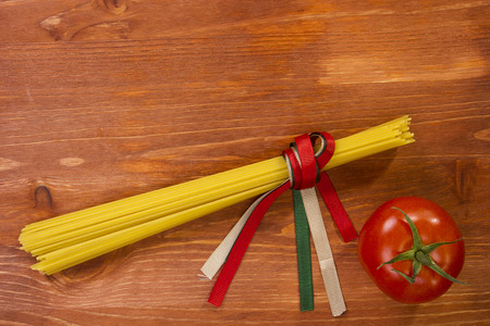 Pasta spaghetti Italian flag colors ribbons tied on a wooden tableの写真素材