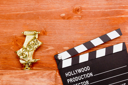 Theatrical masks and movie clapper on wooden backgroundの写真素材