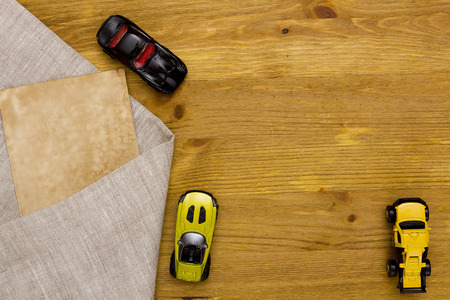 Toy models of cars and a linen cloth on a wooden tableの写真素材