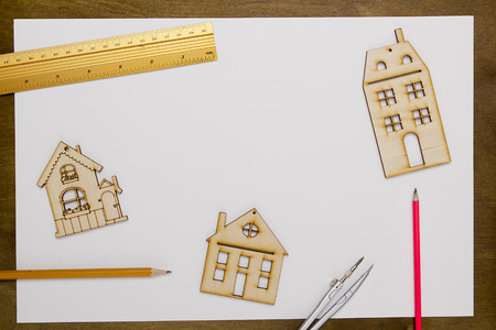 Model home on a white sheet of paper on a wooden tableの写真素材