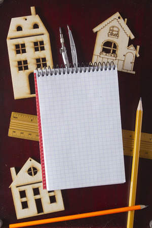Model house and drawing tools on a wooden tableの写真素材
