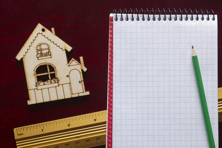 Model house and drawing tools on a wooden tableの写真素材