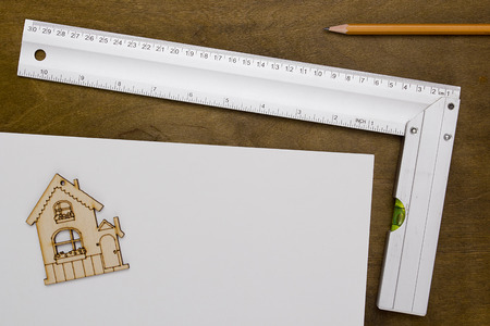 Model house and drawing tools on a wooden tableの写真素材
