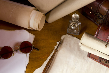 Vintage scrolls and tools for writing in ink on a wooden tableの写真素材