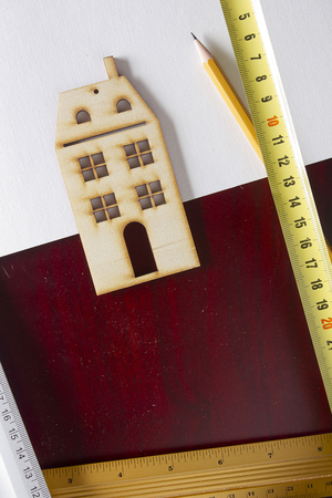 Model house and drawing tools on a wooden tableの写真素材
