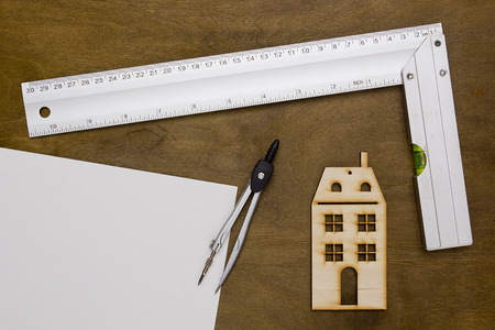 Model house and drawing tools on a wooden tableの写真素材