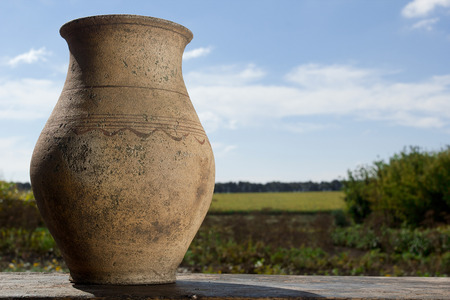 Clay jug with milk on a background of the rural landscapeの写真素材