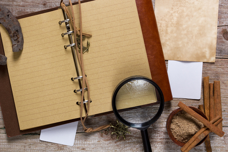 Cinnamon and note pad on an old wooden tableの写真素材