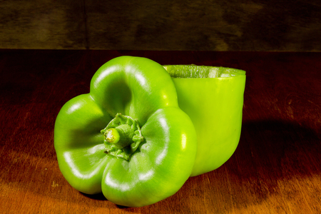 Green bell peppers ready to be stuffed on a wooden tableの写真素材