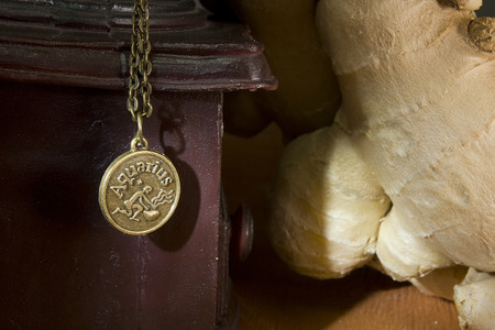 Ginger root and sign of the zodiac on a wooden backgroundの写真素材