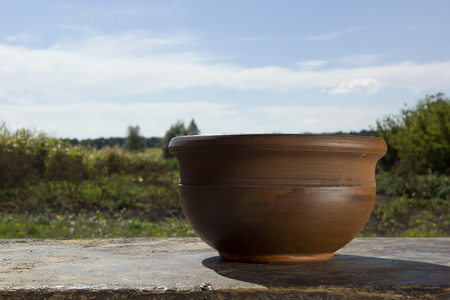 Brown ceramic pot on a background of the rural landscapeの写真素材