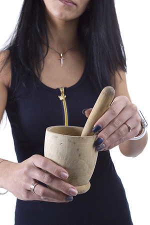 Wooden mortar in female hands on a white backgroundの写真素材